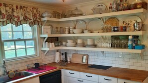 Una cocina con armarios de madera, un lavamanos y un ventilador de techo.