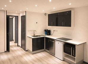 Een moderne keuken met geïntegreerde apparatuur, een inbouwoven en een vaatwasser.