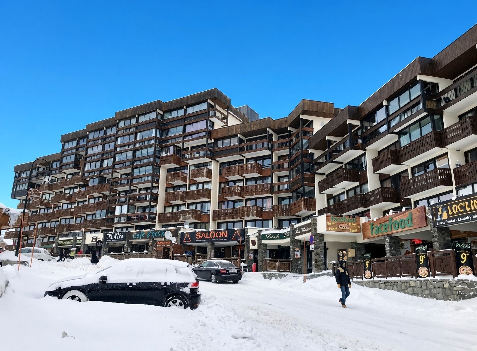 A multi-story hotel with balconies, a cafe, and a face food restaurant.