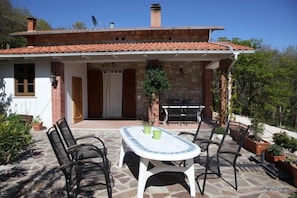 Enjoy outdoor dining or relaxation on the covered patio with a table and chairs.