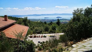 Vista desde una terraza en la azotea con vistas a una masa de agua, una isla distante y colinas ondulantes.