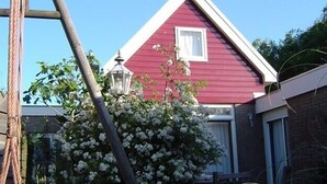 Una casa roja con una ventana y una puerta blancas.