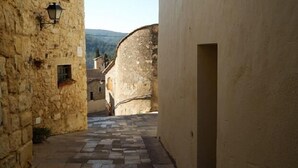 Un estrecho sendero de piedra que conduce a un edificio con techo de tejas.