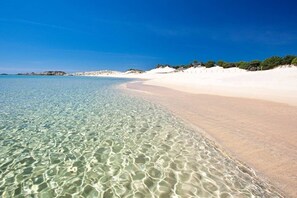 A beach with clear shallow waters and a sandy shore. - Casa V & G - comfortable and practical Chia holiday home (Chia)