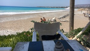 A beach view with a wooden pergola, lounge chairs, and a stone sculpture. - Luxury Private 3 bedroom (sleeps 6)Villa, Breathtaking Views & 200mbps Wi-Fi (Paphos)