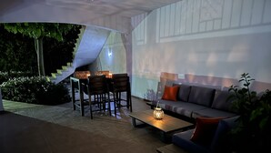 An outdoor patio area with a sofa, chairs, a table, and a lantern. - Luxury Private 3 bedroom (sleeps 6)Villa, Breathtaking Views & 200mbps Wi-Fi (Paphos)