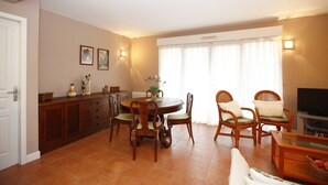 A dining area with a round table, wooden chairs, and a cabinet with decorative items. - house / villa - Hendaya with swimming pool (Hendaye)