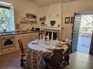A kitchen with a dining table set for four, a fireplace, and a view of the outdoors.