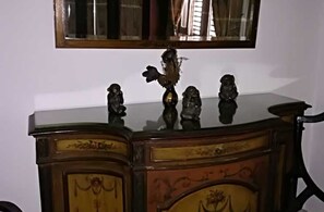 Ein Holzschrank mit verzierten Schnitzereien und einem Spiegel darüber.