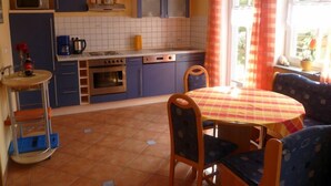 A compact kitchen with a dining area, featuring a tiled backsplash, a microwave, a stove, and a sink. - Family-friendly 4 * Holiday, Pets Allowed, N. Ground corn, Hiking (Kirchberg i. Wald)