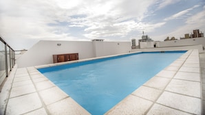 Ein Dachpool mit blauem Himmel und Stadtansicht im Hintergrund.