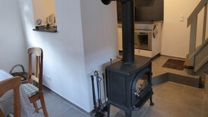 Eine Küche mit Kaminofen, Backofen und einer Treppe.