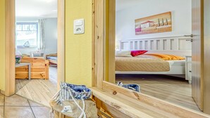 A bedroom with a bed, bedside table, and a mirror. - Comfortable, quiet 3-room first floor apartment, garden, fireplace and underfloor heating (Mecklenburg-Vorpommern)