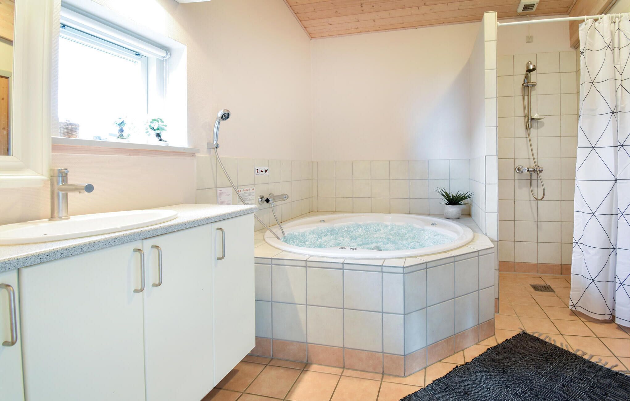 A bathroom with a bathtub, shower, and sink.