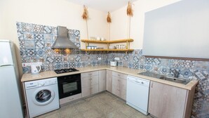 A compact kitchen with a washing machine, a stove, a dishwasher, and a sink.