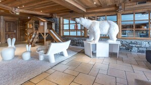 Ein Blockhaus-Interieur mit Steinwand, Holzboden und einer Skulptur eines Eisbären.