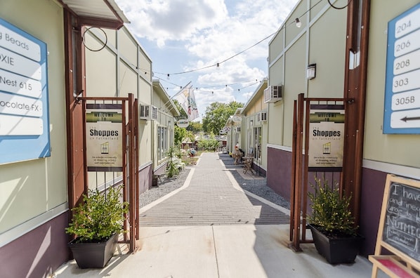 A narrow pedestrian street lined with shops, wooden gates, and potted plants. - Best location in East Nash! 1.5 miles to Nissan Stadium and downtown Nashville!
(Nashville)
