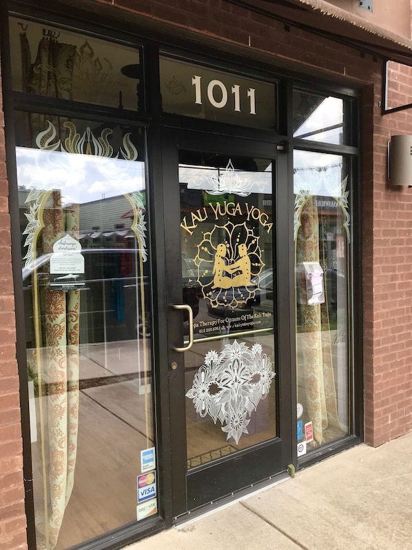 A storefront with a glass door, number 1011, and a sign for Kali Yuga Yoga.