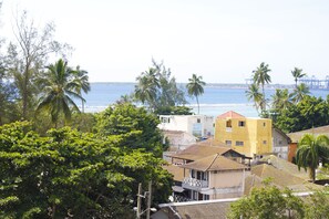Une ville côtière avec des bâtiments, des palmiers et une vue sur la mer.