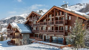 A multi-story wooden chalet with balconies, set in a snowy mountainous area. - Cozy 3-room apt with pool, spa & parking - 6 guests (Saint-Martin-de-Belleville)