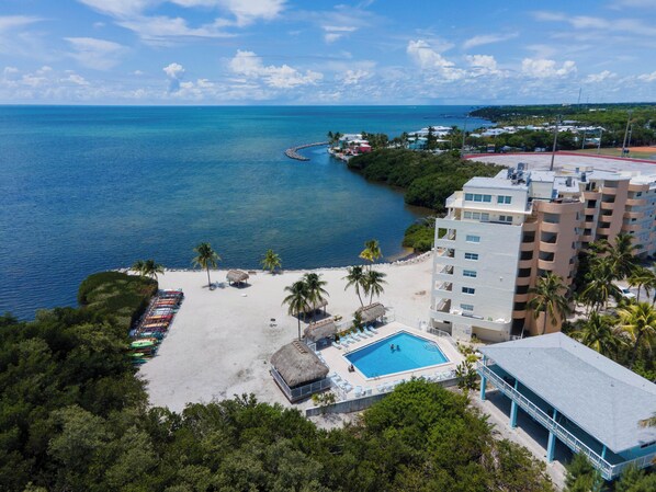 Un complexe hôtelier doté d’une piscine, d’une plage et offrant une vue sur l’océan.