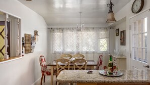 Spiseområde med ø, marmor, træstole og en lysekrone.