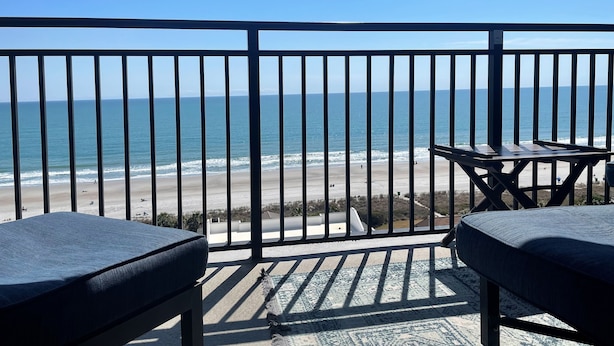 Un balcón con vista a la playa y al océano.