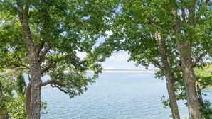 A natural landscape with trees framing a body of water. - Eagles Nest at CrossTimbers Marina (Sperry)