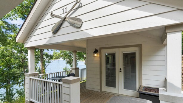 A covered porch with a grill, a door with a glass panel, and a number '11' sign. - Eagles Nest at CrossTimbers Marina (Sperry)