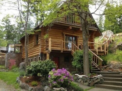 Gemütliches rustikales Blockhaus, das mit hölzernem Kamin und heißer Wanne lebt