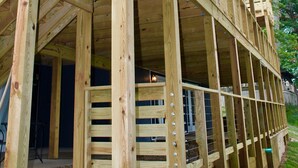 Estrutura de deck de madeira com guarda-corpos e escadas, possivelmente parte de um edifício residencial.