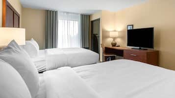 A hotel room with two beds, a TV, a desk, and a chair.