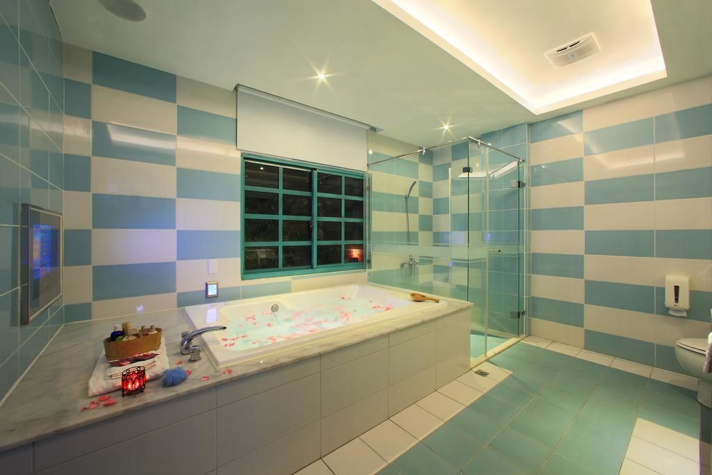 A modern bathroom with a large bathtub, a glass shower enclosure, and a window with a view.