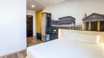 Une chambre d’hôtel avec un grand lit, une armoire, un bureau avec une chaise et un téléviseur fixé au mur.