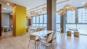 A modern dining area with white tables and chairs, large windows, and hanging wicker lamps. - B&B Hotel Roma Fiumicino Aeroporto Fiera 1 (Fiumicino)