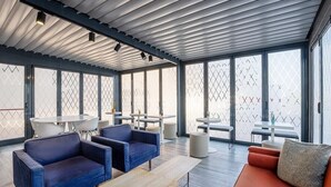 A modern lounge area with sofas, tables, and a high ceiling with skylights. - B&B Hotel Roma Fiumicino Aeroporto Fiera 1 (Fiumicino)