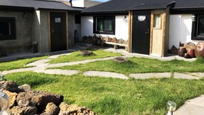 Un edificio moderno con un patio que incluye escalones de piedra y un área ajardinada.