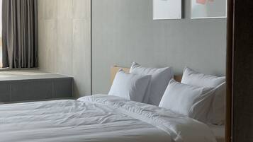 Un dormitorio moderno con una cama grande, una ventana con cortinas y dos obras de arte enmarcadas en la pared.