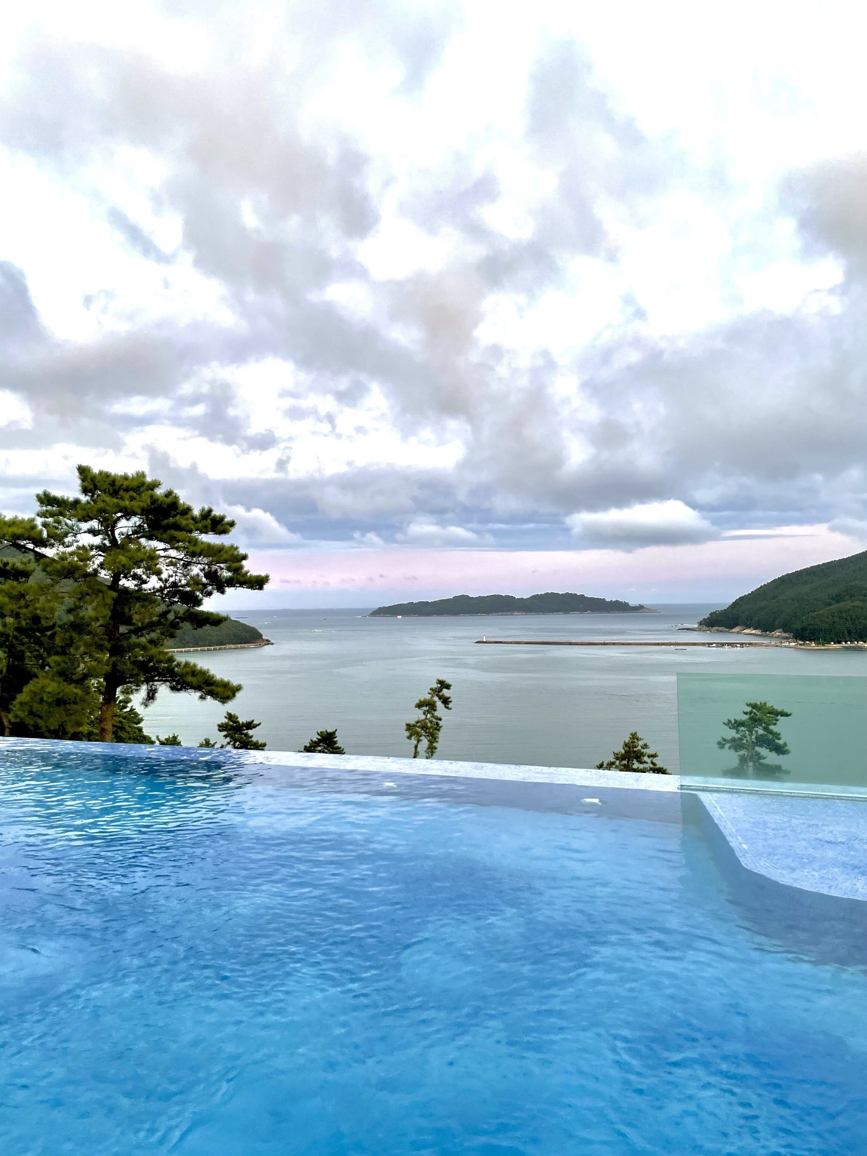 Une piscine à débordement offrant une vue sur la mer et les îles lointaines.