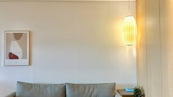 Una sala moderna con un sofá, una mesita y una lámpara colgante.