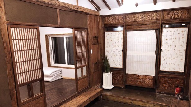 Um quarto japonês tradicional com tatames, portas deslizantes e um banco de madeira baixo.