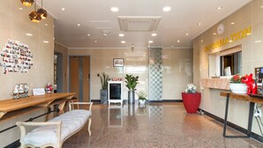 A hotel reception area with a bench, a reception desk, a clock, and a wall with a 'Information' sign. - Fantastic Ocean View Sydney Hotel (Jeju City)