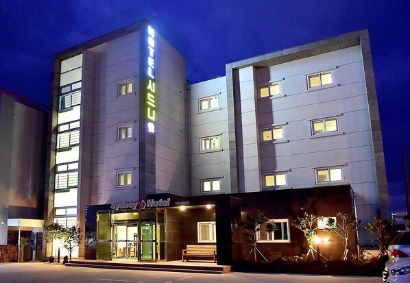 A Sydney Hotel with a modern design, featuring a prominent vertical sign and a well-lit entrance. - Fantastic Ocean View Sydney Hotel (Jeju City)
