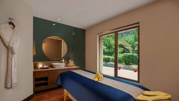 Relax in a serene space with a large bed, wooden bench, and a view of lush greenery.