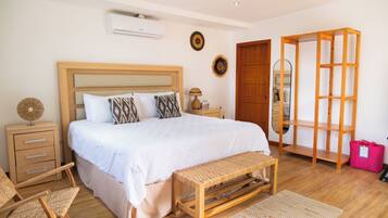 A bedroom with a wooden bed, bedside tables, a bench, and a wardrobe.