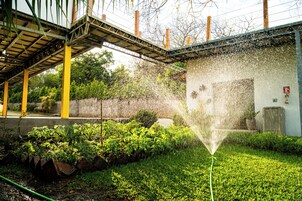 Un jardín con fuente de agua, un puente y un edificio con un hidrante.