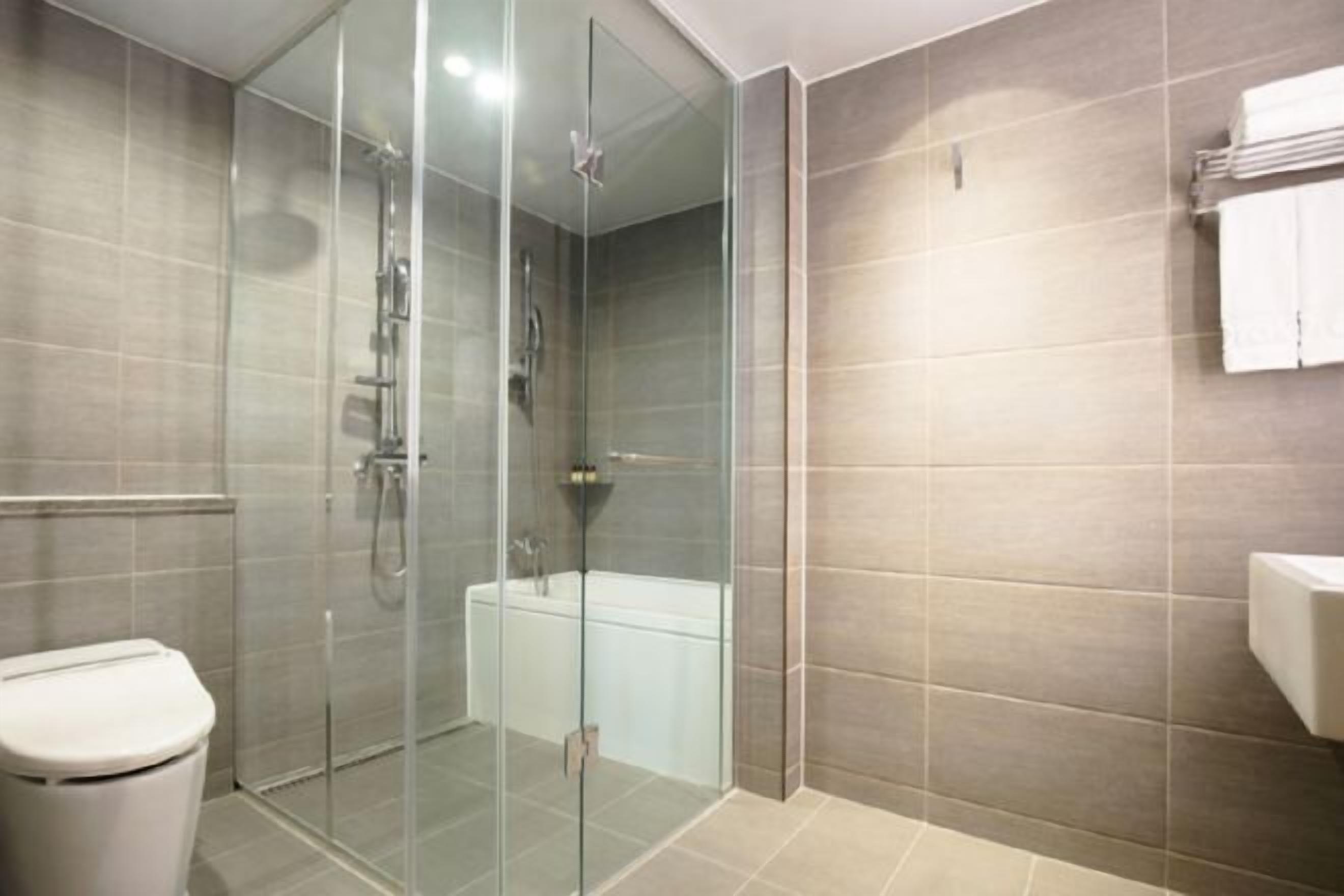 Badkamer | Een haardroger, badjassen, pantoffels, een bidet