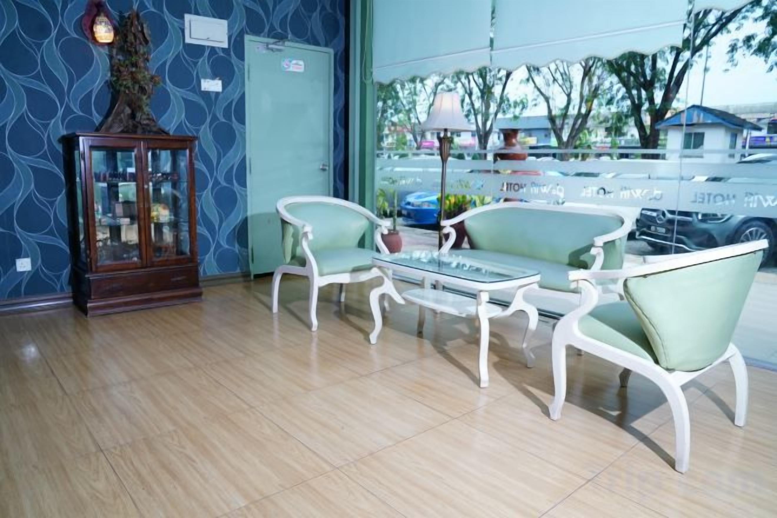 Ein Zimmer mit Glastisch, zwei Stühlen, einem Schrank und Blick ins Freie.