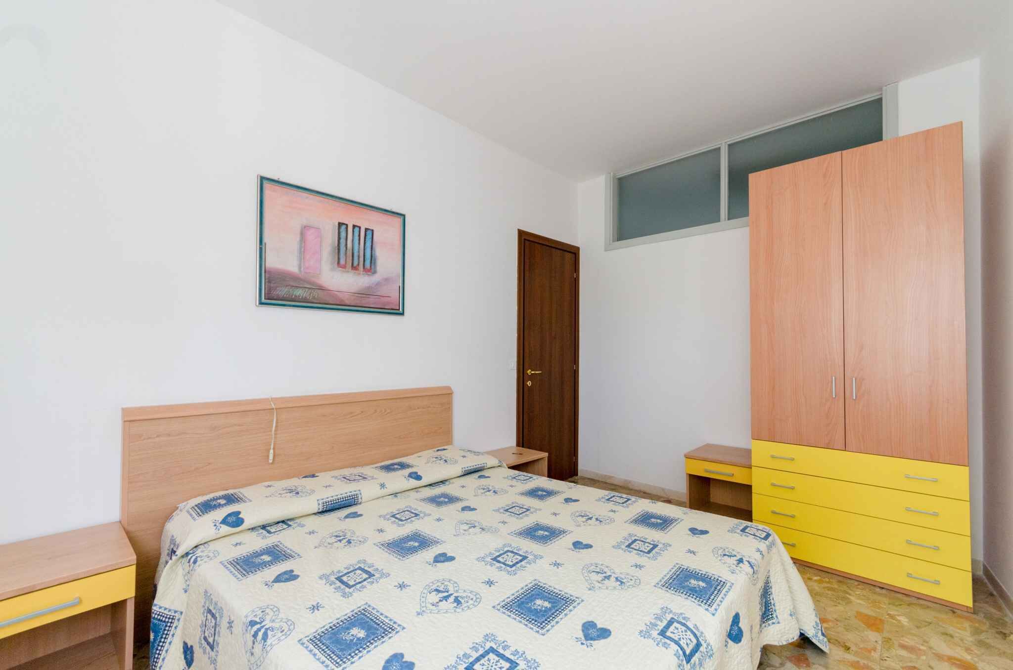 Un dormitorio con cama, armario, escritorio y puerta.