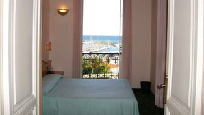 A narrow room with a bed, a window, and a view of a marina. - Studio mit Pool (Imperia)